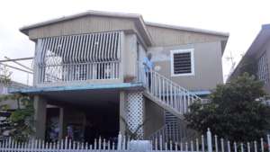 Hector in front of his newly-roofed home