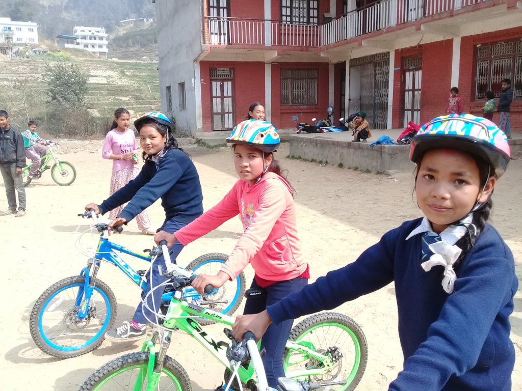 Girls learn to ride new bikes for their school run