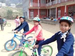 Girls learn to ride new bikes for their school run