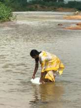 Woman collecting water from unsafe source