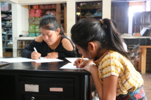 Dolores y Julisa escribiendo palabras en Tz'utujil