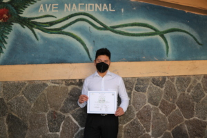 Misael displaying his diploma