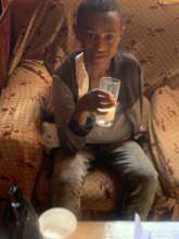 Alemu in his home drinking milk and resting