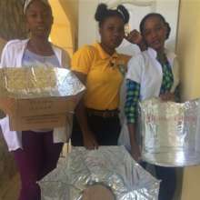 Three students with their solar cooker homework