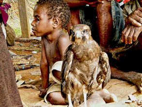 A boy and a bird of prey relax together