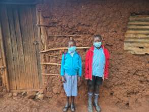 Ondicho (8) and Lucy (6) in front of their home