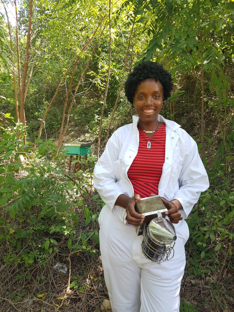 A beekeeper who received a Kiva loan for equipment