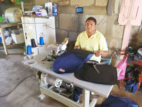 Juan sewing a backpack with his new sewing machine