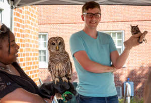 Two educators teaching with Screech and Barred Owl