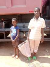 Young mother and her child receiving food aid bag