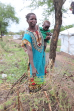 Fatima* and her child with a moringa seedling