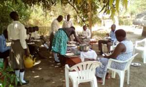 Project Leader and other leaders eating with girls