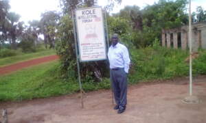 Director stands alongside organizational signpost