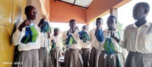 Girls posse with the facemasks they are making