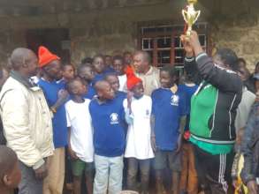 Getry giving trophy to winning soccer team.