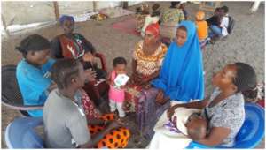 Women with children in small group discussion.