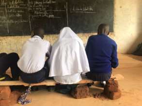 Students on a bench taking notes