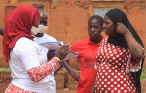 A health worker talks to mothers about COVID-19