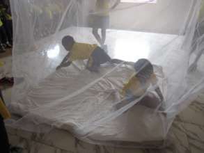 Students learning how to set up their bed net