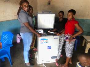 Maendeleo club mini-restaurant receiving a fridge