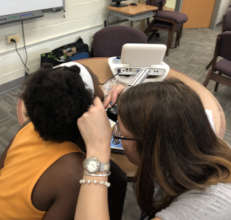 A CC audiologist examines the inner ear of a child