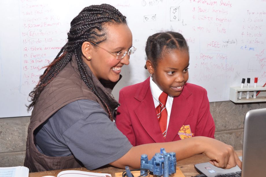 A woman and a young student use a computer together