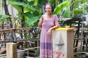 Woman drinking from her new BioSand filter