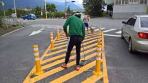Children carefully clean in the middle of the road
