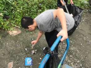 A Boy bend down to pick up trash