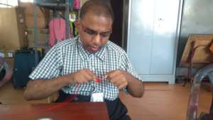 Naveen engrossed in making a colourful pompom