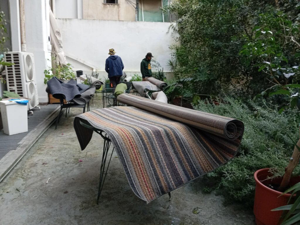 Community members help hang carpets after flood