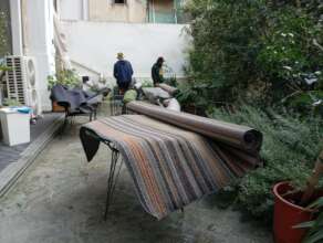 Community members help hang carpets after flood