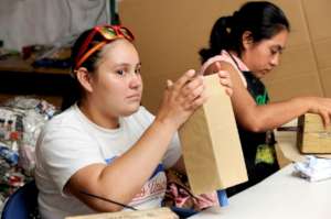 Xochitl works making paper bags.