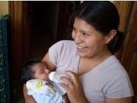 Mother bottle feeding newborn