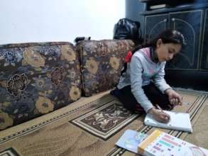 Maram, 12, studies at her home in Syria.