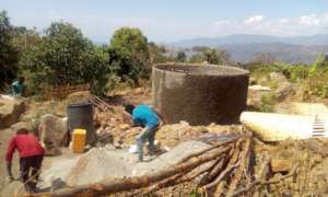 Community members help build a water tank