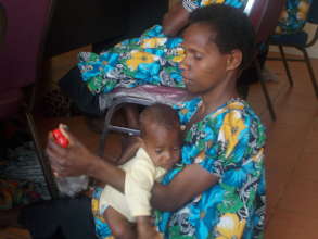 Village Midwife in training session with baby