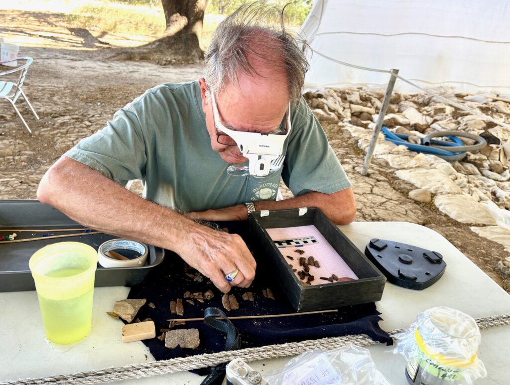 A volunteer cleaning an artifact