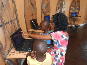 Pauline teaching computer games to two little ones