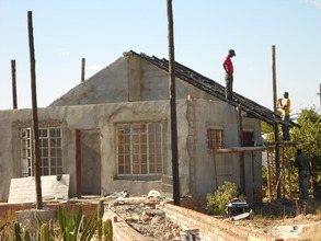 Foster & Tinashe installing roof on cottage