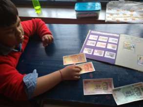 Child identifying 20 Rupee note using TLMs