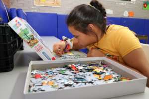 A girl highly concentrated resolving a puzzle