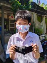 A Thai student with the mask he decorated.