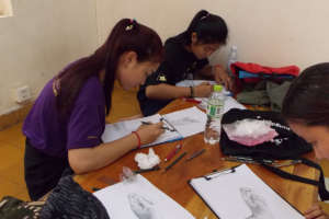 Students practice drawings of dancer's hand