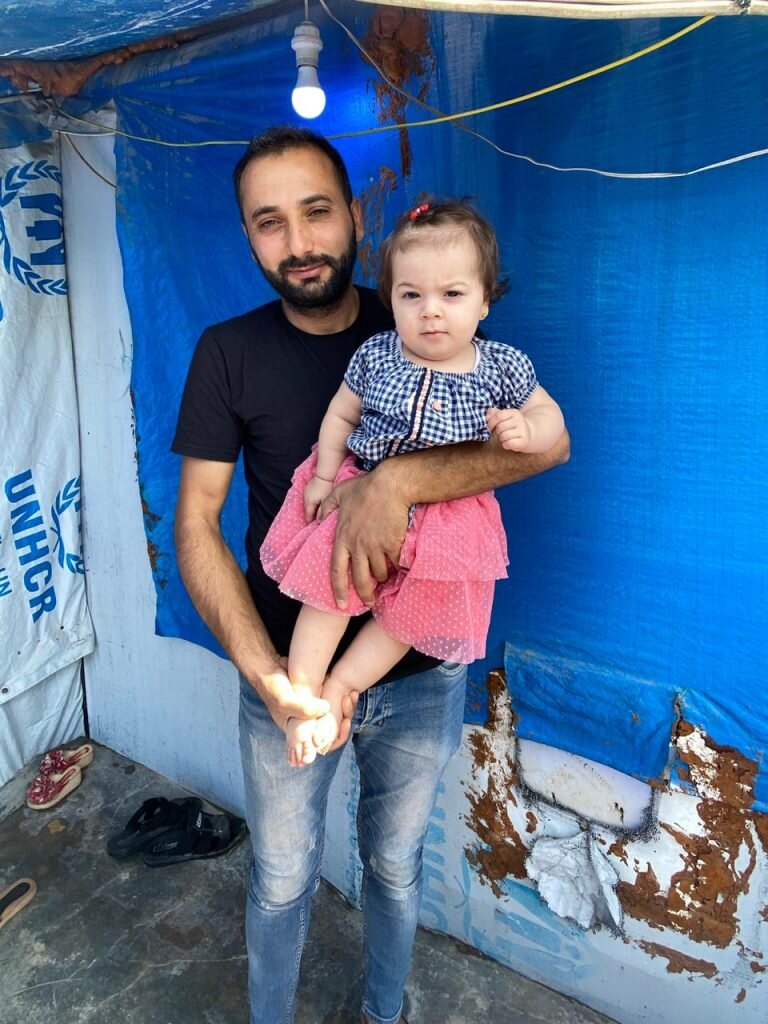 Syrian refugee father and daughter in tent in Iraq