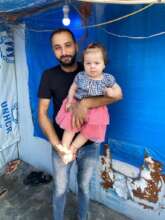 Syrian refugee father and daughter in tent in Iraq
