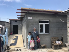 A family poses with their new home in Erbil