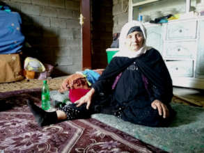 A woman sits in a temporary shelter
