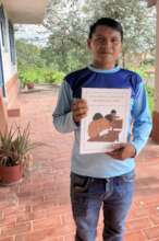 Educator Jkali receives a copy of the primer