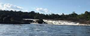 Passing the river rapids pushing the canoe